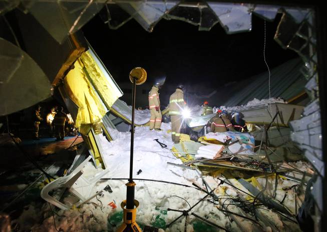 Rescue workers search for survivors from a collapsed resort building in Gyeongju, South Korea, Monday, Feb. 17, 2014. Four university students died and about 10 were feared trapped after the roof of a building collapsed in a southeastern city during a welcoming ceremony for freshmen, South Korean officials said Tuesday.