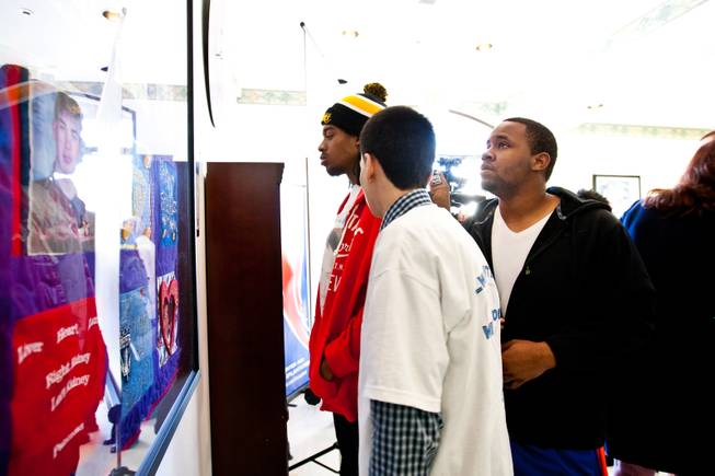 Close friends of Aric Brill, from right, Melvin Gibson, Reuben Moran and Anthony McKenzie admire a homemade, patchwork quilt hung in honor of Brill during a ceremony celebrating the life of 16-year-old Aric Michael Brill, who donated six organs following his homicide five years ago, at the UMC Transplant Center Friday, February 21, 2014.