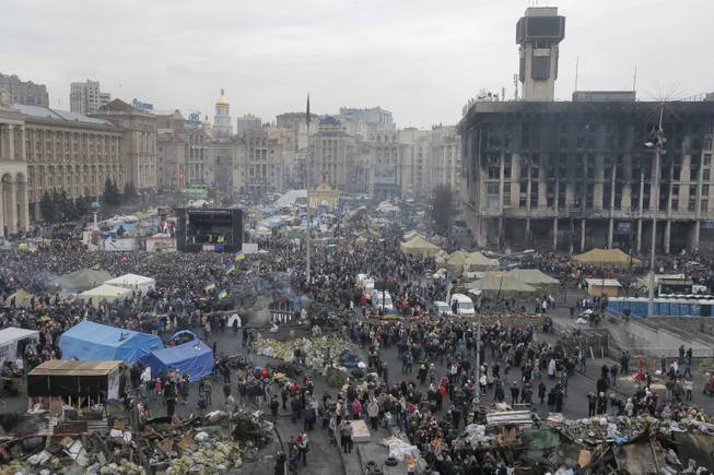 General view of Kiev's Independence Square, the epicenter of the country's recent unrest, Ukraine, on a mourning day Sunday, Feb. 23, 2014. Official reports say 82 person were killed in severe clashes between opposition activists and riot police. A destroyed trade union house which was burned in clashes seen in the background right.