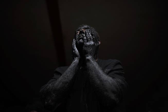 A man covers his face in oil and soot as he gets ready to start the carnival festival in the small village of Luzon, Spain, Saturday, March 1, 2014. Preserved records from the 14th century document Luzon's carnival, but the real origin of the tradition could be much older. Carnival festivals are celebrated in their own way around hundreds of villages in Spain.