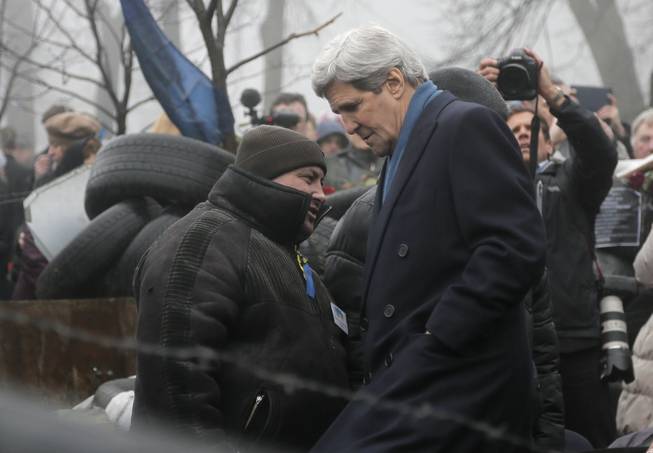 U.S. Secretary of State John Kerry, right, inspects protesters barricades in Kiev, Ukraine, Tuesday, March, 4, 2014. In a somber show of U.S. support for Ukraine's new leadership, Kerry walked the streets Tuesday where nearly 100 anti-government protesters were gunned down by police last month, and promised beseeching crowds that American aid is on the way. The Obama administration announced a $1 billion energy subsidy package in Washington as Kerry was arriving in Kiev.