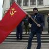 Photo: Local residents hold a Soviet flag as members of C Photo: Local residents hold a Soviet flag as members of C
