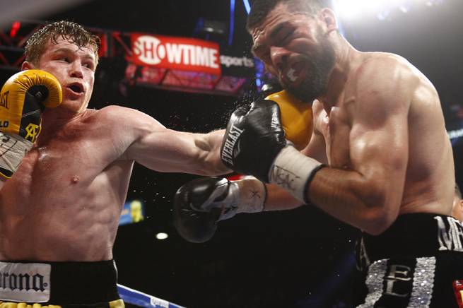 Canelo Alvarez, left, connects on Alfredo Angulo, both of Mexico, during their super-welterweight fight Saturday, March 8, 2014, at MGM Grand Garden Arena