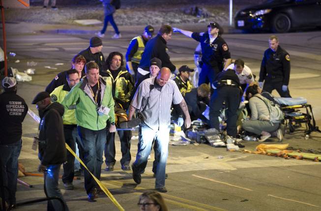 Paramedics tend to victims after several people were struck by a vehicle on Red River Street in downtown Austin, Texas, at SXSW on Wednesday March 12, 2014. Police say two people were confirmed dead at the scene after a car drove through temporary barricades set up for the South By Southwest festival and struck a crowd of pedestrians.