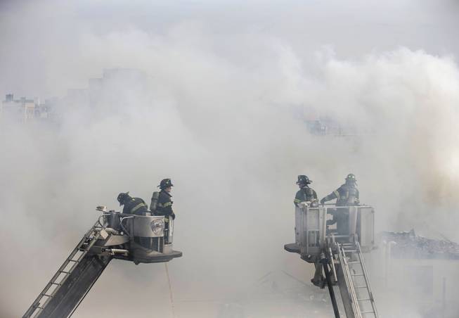 Firefighters respond to an explosion that leveled two apartment buildings in the East Harlem neighborhood of New York, Wednesday, March 12, 2014. Con Edison spokesman Bob McGee says a resident from a building adjacent to the two that collapsed reported that he smelled gas inside his apartment, but thought the odor could be coming from outside.