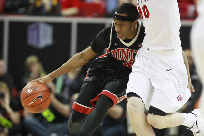 UNLV guard Kevin Olekaibe pushes the ball up court while being defended by San Diego State forward Matt Shrigley during their Mountain West Conference semifinal game Friday, March 14, 2014 at the Thomas & Mack Center. The #8 ranked San Diego State Aztecs won 59-51 to advance to the finals.