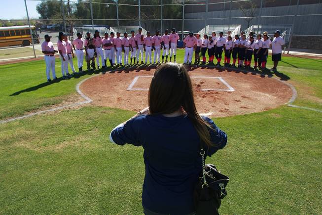 Kelly Webb from the Candlelighters takes a photo of the Canyon Springs baseball and softball teams before their game against Western Wednesday, March 19, 2014. The Pioneers wore pink jerseys for the game for cancer awareness and to honor parents of two of the players who died from cancer in the past year.