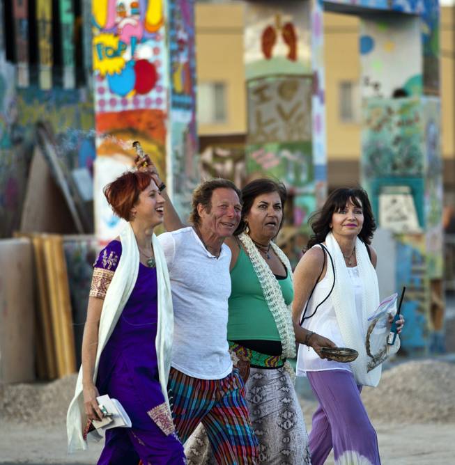 Artist Scott Cohen walks by his Life Cube, an interactive community art installation, with, from left, Cheryl Slater, Mary Lou Anderson, and Natalie Johnson after saying the cube in downtown Las Vegas, Friday March 21, 2014. The Life Cube, later burned, was a 24-by-24-foot plywood cube, painted by artists and filled with notes from thousands of people.