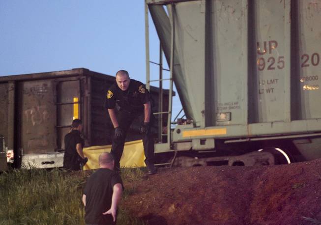 Emergency personnel work at the scene of a train accident where two pedestrians were hit near Earle Yorton Field on Friday, March 21, 2014, in Marysville, Calif. A teenage boy is dead and a teenage girl critically injured after they were hit by the freight train while walking to a high school dance.