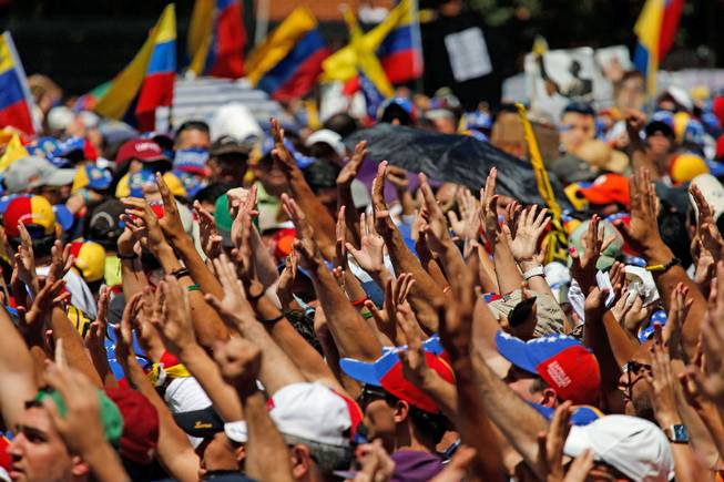Supporters hold out their hands to greet Carlos Vecchio, the national political coordinator of the Popular Will party, an anti-government group formed by jailed opposition leader Leopoldo Lopez before his arrest, during an anti-government protest in Caracas, Venezuela, on Saturday, March 22, 2014.