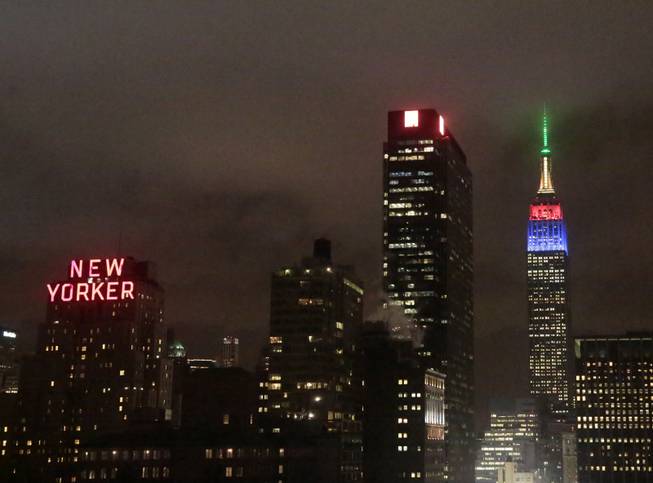 The Empire State Building, right, rises into the climbs into the New York City skyline lit in the colors of the South African Flag to observe the passing of former South African President and Civil Rights leader Nelson Mandela, Friday, Dec. 6, 2103 in New York. Mandela died on Thursday, Dec. 5, 2013 at age 95.