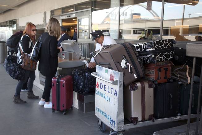 Passengers are shown getting checked in before a flight Thursday March 27, 2014 at Los Angeles International Airport in Los Angeles. Police say six people were arrested Wednesday March 26, after officers served more than two dozen search warrants after a months-long investigation into baggage theft at Los Angeles International Airport. Officials say those arrested were primarily employees or ex-employees of contracting companies hired to handle luggage and do not work for the airport itself.