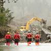 Photo: Four search and rescue workers wade through water Photo: Four search and rescue workers wade through water