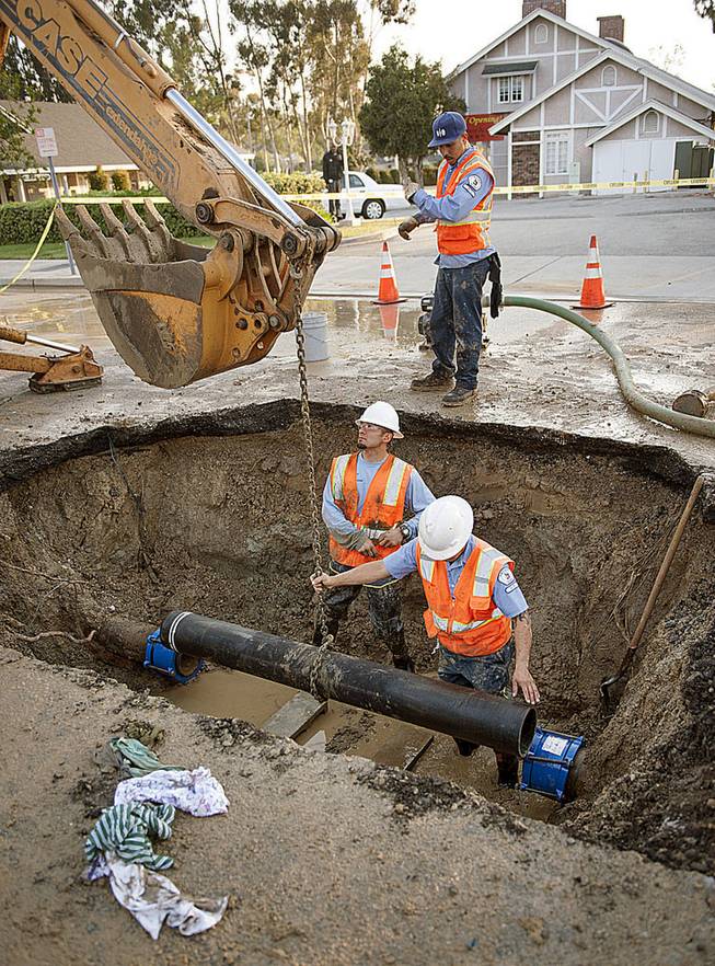 City of Fullerton maintenance workers Ernie Vejar, left, Eric Becerra and Andrew Grajeda, above, lower in a new section of pipe Saturday, March 29, 2014, as they work on repairing a main water line in Fullerton, Calif. More than 100 aftershocks have rattled Orange County south of Los Angeles where a magnitude-5.1 earthquake struck Friday. Despite the relatively minor damage, no injuries have been reported. (AP Photo/The Orange County Register, Ken Steinhardt) MAGS OUT; LOS ANGELES TIMES OUT