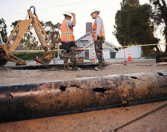 City of Fullerton maintenance workers Eric Becerra, left, and Ernie Vejar wait for a new section of pipe to be cut early Saturday, March 29, 2014 in Fullerton, Calif. More than 100 aftershocks have rattled Orange County south of Los Angeles where a magnitude-5.1 earthquake struck Friday. Despite the relatively minor damage, no injuries have been reported. (AP Photo/The Orange County Register, Ken Steinhardt) MAGS OUT; LOS ANGELES TIMES OUT