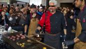 Guy Fieri works a patio grill at The Quad helping to serve burgers to fans outside his first Las Vegas restaurant, Guy Fieri's Vegas Kitchen & Bar on Friday, April 4, 2014.
