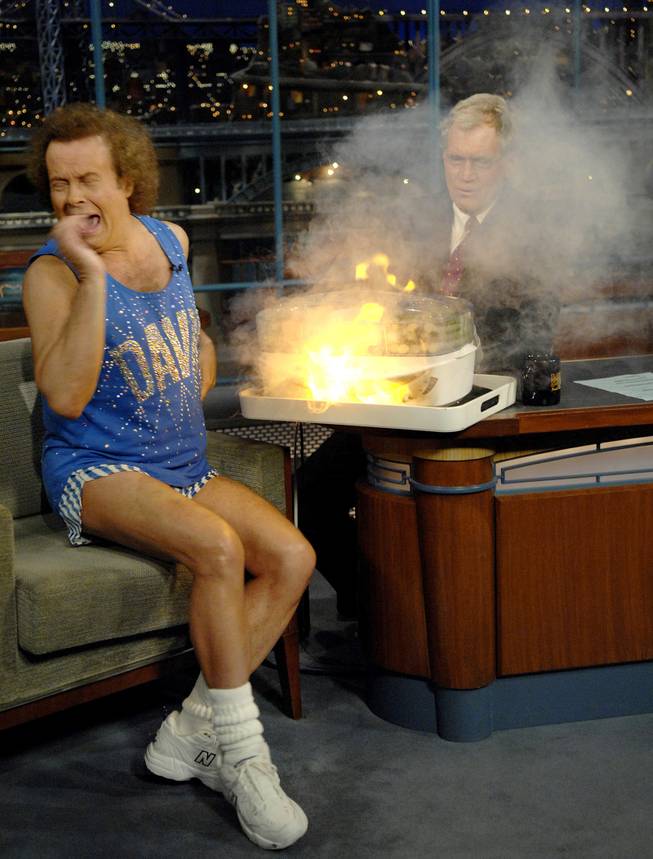 In this photo released by CBS, author and fitness personality Richard Simmons, left, reacts to an explosion under the vegetable steamer as host David Letterman watches from the rear, on the set of the "Late Show with David Letterman" Wednesday, Nov. 29, 2006 in New York. This was Simmons' first appearance on the show in six years.