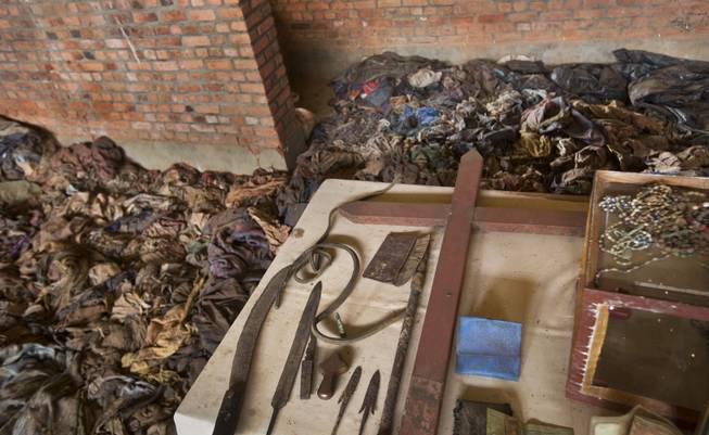 Some of the weapons of the attackers are laid on the altar next to the belongings of some of those who were slaughtered as they sought refuge inside the church, as piles of the clothes of those killed sit on the pews, as a memorial to the thousands who were killed during the 1994 genocide in and around the Catholic church in Nyamata, Rwanda Friday, April 4, 2014.