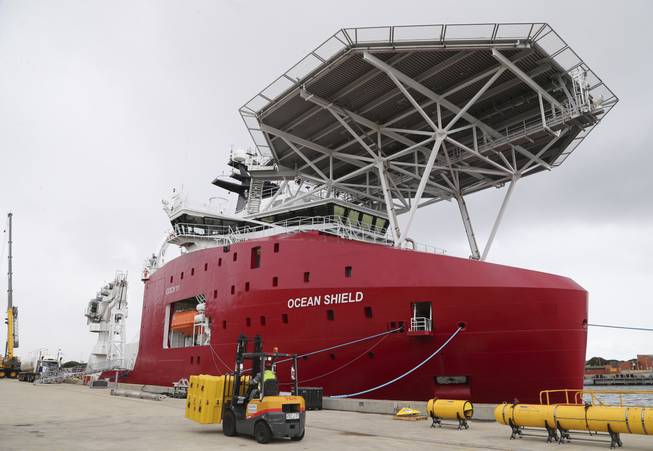 In this Sunday, March 30, 2014, file photo, the Australian navy ship Ocean Shield is docked at naval base HMAS Stirling while being fitted with an autonomous underwater vehicle (AUV), bottom right, and a towed pinger locator (TPL), a small yellow object seen at bottom third from right, to aid in the search for missing Malaysia Airlines Flight MH370.