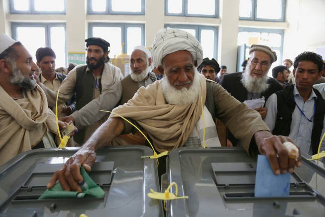 An Afghan man casts his vote at a polling station in Jalalabad, east of Kabul, Afghanistan, on Saturday, April 5, 2014. Afghan voters lined up for blocks at polling stations nationwide on Saturday, defying a threat of violence by the Taliban to cast ballots in what promises to be the nation's first democratic transfer of power. There were few instances of violence.