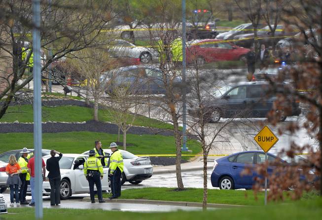 Kansas State Troopers stand near the location of a shooting at the Jewish Community Center in Overland Park, Kan., Sunday, April 13, 2014. Overland Park Fire Department spokesman Jason Rhodes said Sunday afternoon that one person of interest is in custody. Rhodes said the shootings happened at two different locations, but did not specify where the shootings happened.
