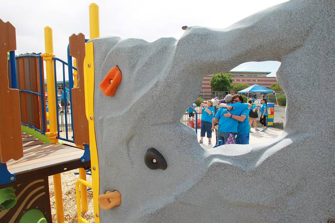 Child Haven supervisor Cindy Fischer gets a hug from volunteer James Reynolds after the ribbon cutting on a KaBoom playground for Child Haven Tuesday, April 15, 2014. Clark County Department of Family Services and Chicanos Por La Causa teamed up with volunteers from DirectTV and local businesses to rebuild the playground that was closed in 2012.