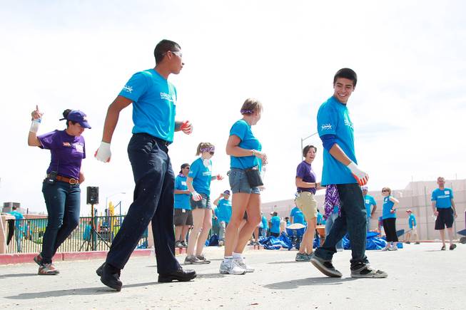 Volunteers take a break and dance to a DJ as they work on building a KaBoom playground for Child Haven Tuesday, April 15, 2014. Clark County Department of Family Services and Chicanos Por La Causa teamed up with volunteers from DirectTV and local businesses to rebuild the playground that was closed in 2012.