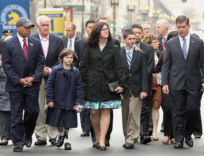 Family members of marathon bombing victims, Martin Richard, Krystle Campbell and Lu Lingzi are joined by Massachusetts Gov. Deval Patrick, left, and Boston Mayor Martin Walsh, right, during a wreath laying ceremony to commemorate the one year anniversary of the Boston Marathon bombings, Tuesday, April 15, 2014, in Boston. (AP Photo/The Boston Globe, Wendy Maeda) BOSTON HERALD OUT, QUINCY OUT; NO SALES