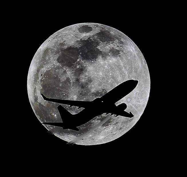 An airliner crosses the moon's path, Monday, April 14, 2014, above Whittier, Calif., approximately one hour before a total lunar eclipse. Then, on April 29, the Southern Hemisphere will be treated to a rare type of solar eclipse. In all, four eclipses will occur this year, two lunar and two solar.