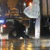 Photo: A member of the bomb squad inspects an object afte Photo: A member of the bomb squad inspects an object afte