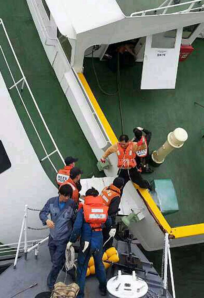 In this photo released by South Korea Coast Guard via Yonhap News Agency, South Korean coast guard rescue passengers from a ferry in the water off the southern coast near Jindo, South Korea, Wednesday, April 16, 2014. The ferry carrying 459 people, mostly high school students on an overnight trip to a tourist island, sank off South Korea's southern coast on Wednesday, leaving nearly 300 people missing despite a frantic, hours-long rescue by dozens of ships and helicopters.