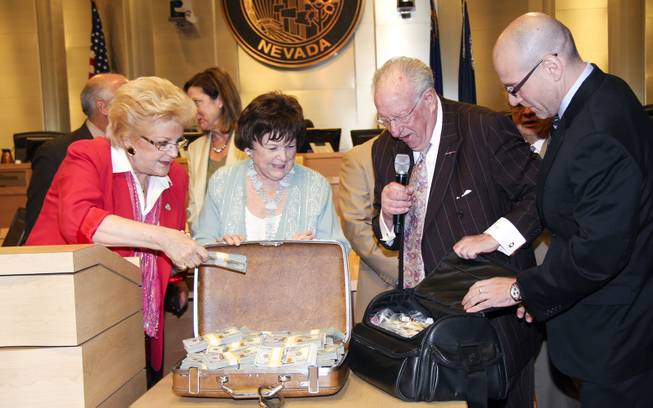 This image provided by the city of Las Vegas shows, from left, Mayor Carolyn G. Goodman, Councilwoman Lois Tarkanian, Oscar B. Goodman and The Mob Museum Executive Director Jonathan Ullman, displaying the $1.5 million in cash paid to the city at a council meeting on April 16, 2014.