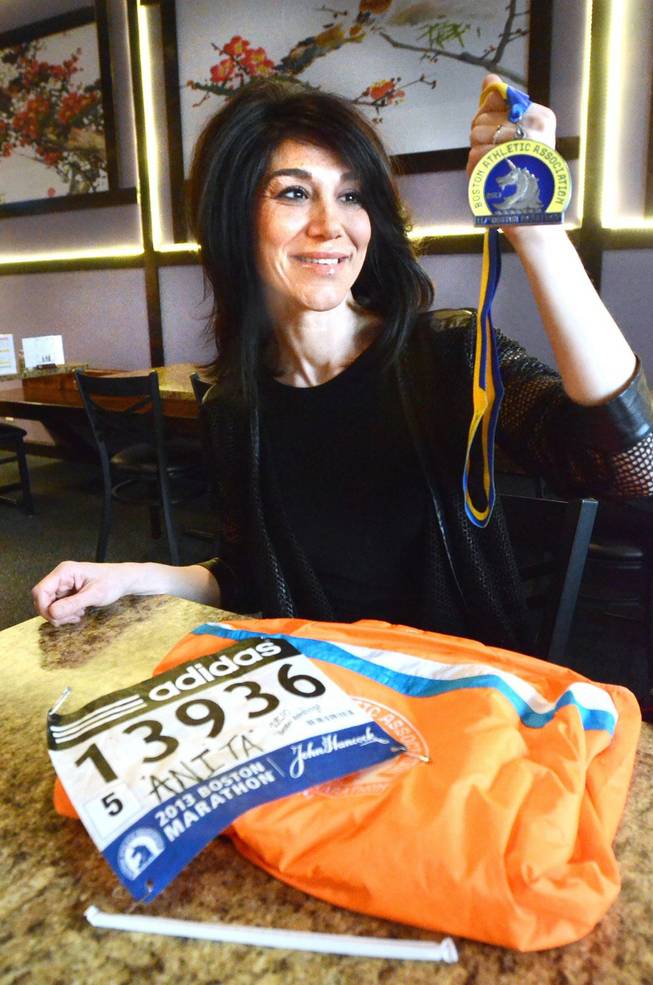 Anita Harless of Holly Township, Mich., shows her medal and runner's number from the 2013 Boston Marathon. Harless finished the race before the bombings and is going to run in this year's race despite the bad memories associated with that day, Harless decided to pay homage to those who can’t be there. She said she needs to attend it as “closure.”