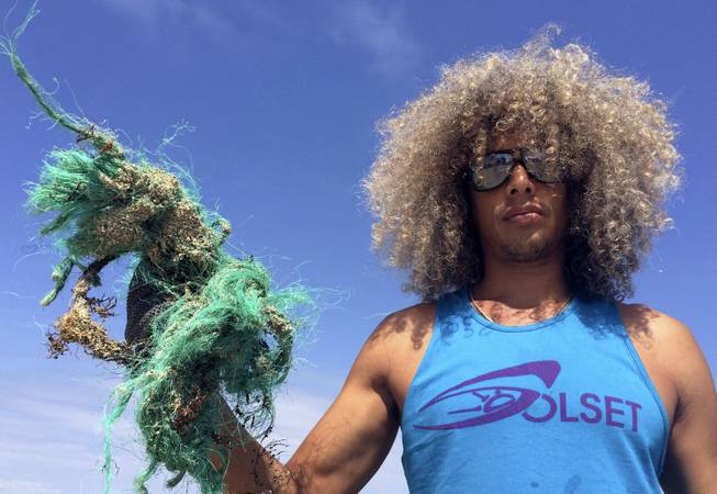 Juan Cedeno, 32, of Miami, holds a handful of plastic fishing line he recovered in rocks along the beach, while volunteering to pick up trash on Earth Day, Tuesday, April 22, 2014, in Miami Beach, Fla. People across the globe held events on Earth Day to celebrate the earth's environment and spread awareness on how to conserve its natural resources.