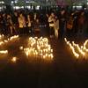 Photo: People stand near candles during a vigil for the s Photo: People stand near candles during a vigil for the s