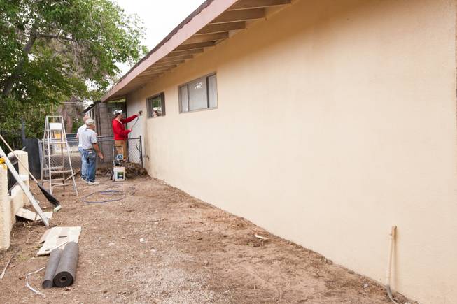 Daniel Strackbein and fellow volunteers complete the spray painting of the home of photographer Robert Scott Hooper and wife Theresa Hooper as part of the Rebuilding Together Southern Nevada's annual neighborhood rebuilding event in Las Vegas Saturday, April 26, 2014.