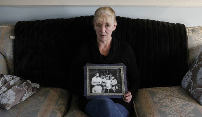 In this Jan. 12, 2012, file photo, Helen McKendry holds a family photo with her mother, Jean McConville, at home in Killyleagh, Northern Ireland. Police in Northern Ireland arrested Sinn Fein party leader Gerry Adams on April 30, 2014, over his alleged involvement in the Irish Republican Army's 1972 abduction, killing and secret burial of McConville. On May 2, the senior Sinn Fein politician in Northern Ireland's unity government demanded Adams' immediate release, as police sought to extend his interrogation over McConville's murder.