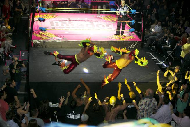 In this Feb. 12, 2014, photo, wrestling duo the Crazy Chickens fly over the ropes and into the audience during the Lucha VaVoom Valentine’s show of Lucha Libre Mexican wrestling and Burlesque performances at the Mayan Theatre downtown Los Angeles. The esoteric hybrid of American burlesque and Mexican wrestling is an outrageous hit.