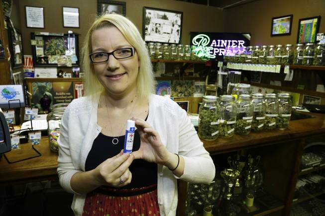 In this photo taken May 2, 2014, Kari Boiter, of Tacoma, Wash., poses for a photo at Rainier Xpress, a medical marijuana dispensary in Olympia, Wash. Boiter has Ehlers-Danlos syndrome, a genetic disorder that causes pain, nausea and vomiting, and says marijuana replaced prescription drugs like steroids and antidepressants what were nearly ineffective for her.