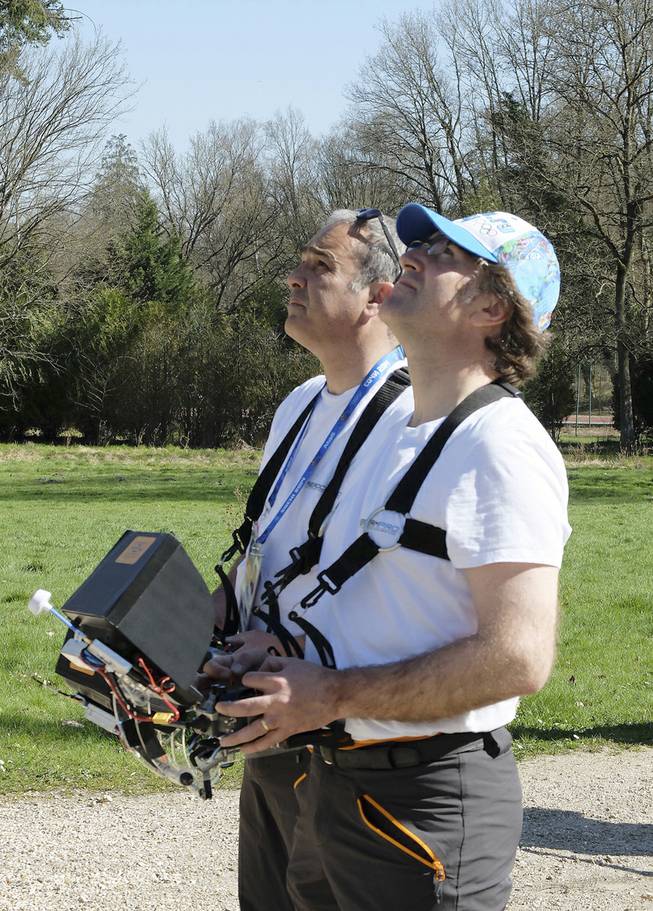 Drone operators Jean-Luc Fornier, left, and Philippe Delafosse control a drone at the Abbaye Des-Vaux-de-Cernay southwest of Paris, Thursday March 20, 2014. French drone operator Jean-Luc Fornier operated the remote controlled drone used to used to transmit live video of snowboard and ski jump competitions at the Sochi Olympic Games.