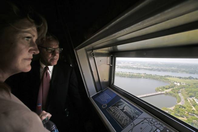 David M. Rubenstein of The Carlyle Group, who partially funded the restoration and Caroline L. Cunningham, take in the view from the 500-foot level at the Washington Monument in Washington, May 12, 2014, after a ceremony to celebrate its re-opening. The monument, which sustained damage from an earthquake in August 2011, reopened to the public today.