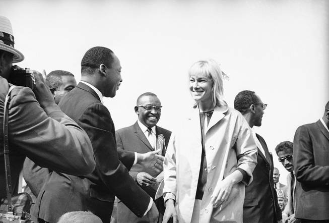 Integration leader Martin Luther King, left, greets actress May Britt one of several Hollywood stars present as she and her husband Sammy Davis arrived at the platform at a mass civil rights rally at Wrigley Field in Los Angeles, May 26, 1963. Dr. King was joined by several other leaders of the Birmingham integration movement.