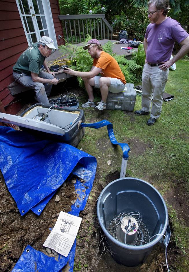 Seismic specialist and UW professor emeritus Steve Malone, left, UW graduate student Carl Ulberg center, and Victor Kress, of the Pacific Northwest Seismic Network, assembled and tested a passive seismic station design in Kress's Lake Forest Park home backyard May 12, 2014. Up to 70 of the passive sensing arrays will be installed up to thirty miles form Mount St. Helen's this spring and summer as part of a battery of multidisciplinary imaging experiments.