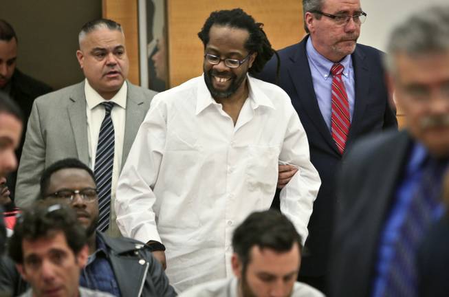 In this May 6, 2014 file photo, Robert Hill, center, smiles as he is escorted into Brooklyn Supreme Court in New York. Hill and his half-brothers Alvena Jennette and Darryl Austin were exonerated in a decades-old conviction investigated by retired homicide detective Louis Scarcella, who has had some of his tactics have come into question. The Brooklyn District Attorney’s Conviction Review Unit is currently re-examining more than cases that Scarcella worked on.