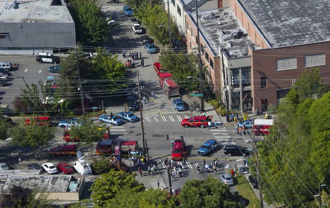 In an aerial view, authorities and other emergency responders gather near Otto Miller Hall, upper left, at Seattle Pacific University on Thursday, June 5, 2014, in Seattle. Police say a university student on Thursday disarmed a lone gunman who entered a building and shot four people. A hospital spokeswoman says one man has died and three other people are injured, one critically. (AP Photo/The Seattle Times, Ellen M. Banner) SEATTLE OUT USA TODAY OUT MAGS OUT; NO SALES; TV OUT; MANDATORY CREDIT TO BOTH THE SEATTLE TIMES AND THE PHOTOGRAPHER