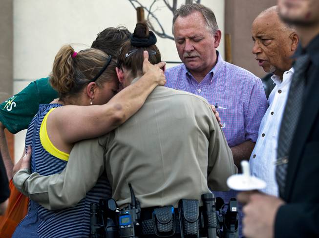 Cheri Rasmussen with the International Church of Las Vegas prays with Metro Police officer T. Bonner following a candlelight vigil outside of CiCi's Pizza restaurant to honor slain officers Alyn Beck and Igor Soldo on Monday, June 9, 2014. They are joined by Ryan and Mark Rasmussen and other supporters.