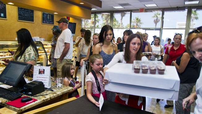 Some customers purchase their pre-ordered cupcakes as others wait patiently in line at Freed's Bakery of Las Vegas to donate and purchase some 35,000 cupcakes for $1 each on Wednesday, June 11, 2014. The proceeds will be going to aid the families of slain Metro Police officers Metro officers Alyn Beck and Igor Soldo.