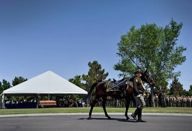 Las Vegas police officer Dallas Reed leads a riderless horse during funeral services for Las Vegas police officer Igor Soldo at Palm Northwest Mortuary & Cemetery on Thursday, June 12, 2014 in Las Vegas. Soldo, 31, and fellow officer, Alyn Beck, 41, were gun down by two assailants at a Cici's Pizza during their lunch break Sunday. Services for Beck are scheduled for Saturday.