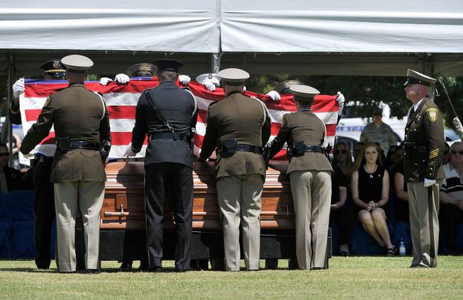 Andrea Soldo, second right, watches the flag folding ceremony during the funeral services for her husband and Las Vegas police officer Igor Soldo at Palm Northwest Mortuary & Cemetery on Thursday, June 12, 2014 in Las Vegas. Soldo, 31, and fellow officer, Alyn Beck, 41, were gun down by two assailants at a Cici's Pizza during their lunch break Sunday. Services for Beck are scheduled for Saturday.