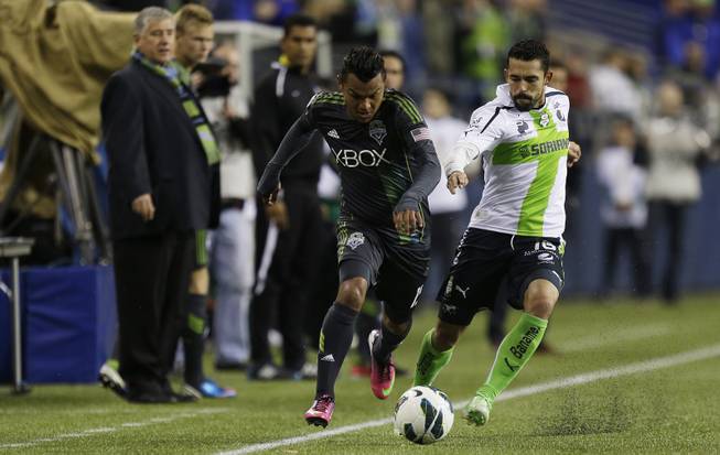 Santos Laguna's Herculez Gomez, right, battles for the ball with Seattle Sounders' Mario Martinez, left, down the sideline in the second half of a CONCACAF semifinal soccer match, Tuesday, April 2, 2013, in Seattle. Gomez had the winning goal as Santos Laguna beat the Sounders 1-0 in the first of two aggregate-score matches.